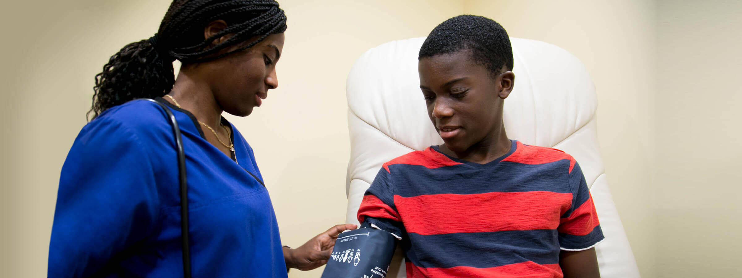 Nurse taking a child's blood pressure in a doctor's office