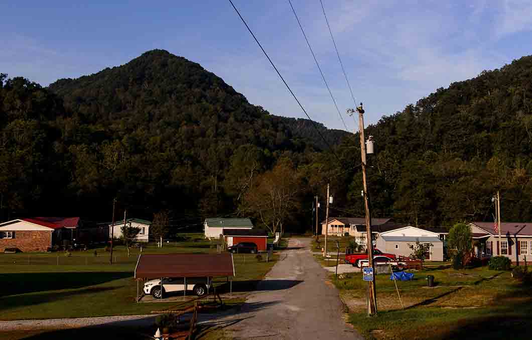 A picture of a small grouping of homes along a single road in a mountainous rural area