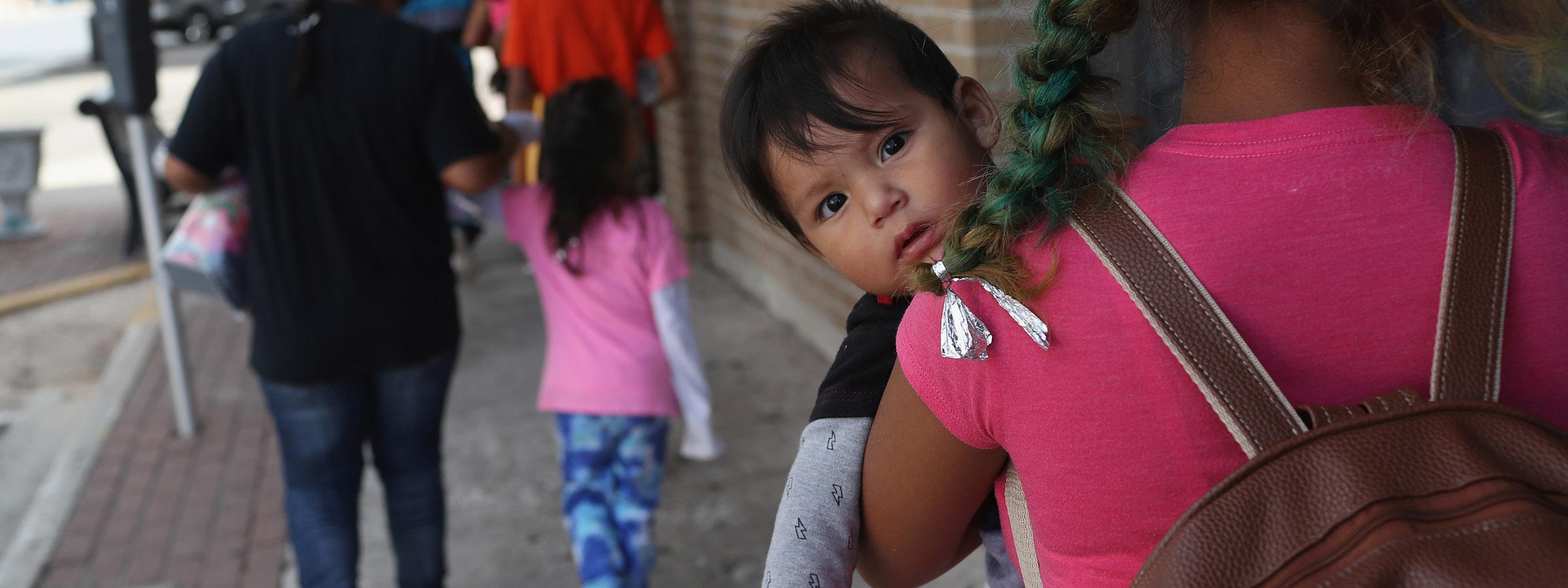 Immigrant baby held by mother.