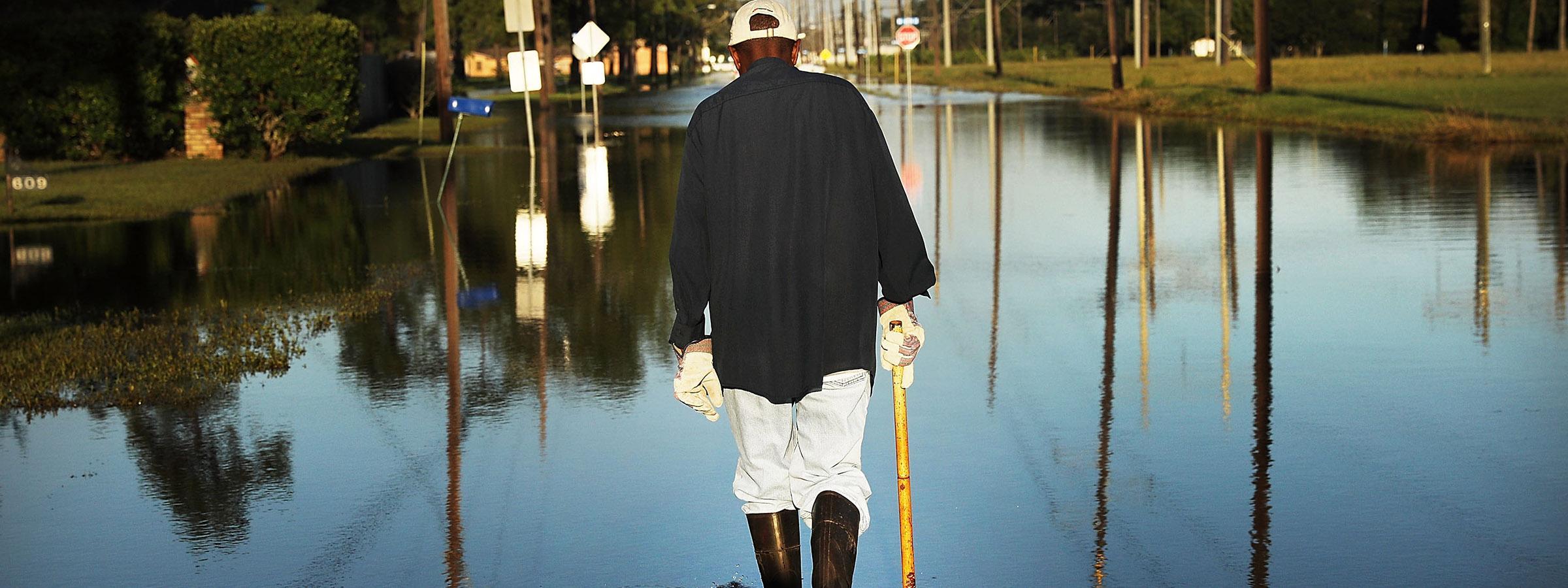 Man walking on flooded streets after a hurricane.