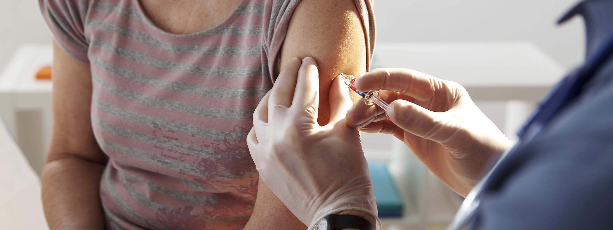 Woman receives a flu shot from doctor