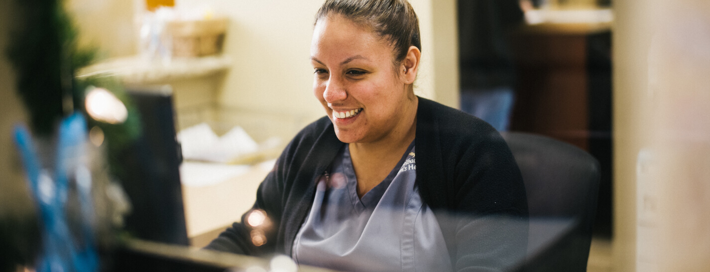 Female hospital staff laughs while using automated revenue cycle tools