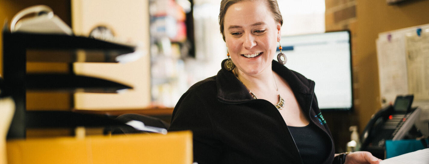 A member of a clinical staff smiles, while using a successful value-based care system.