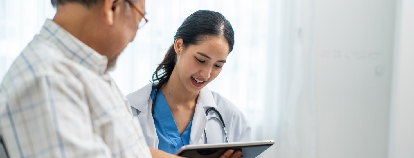 Physician reviewing electronic health records with Medicare patient