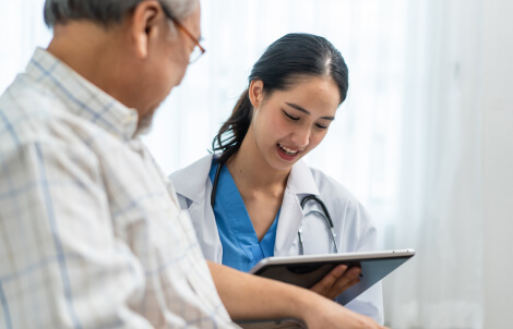 Physician reviewing electronic health records with Medicare patient