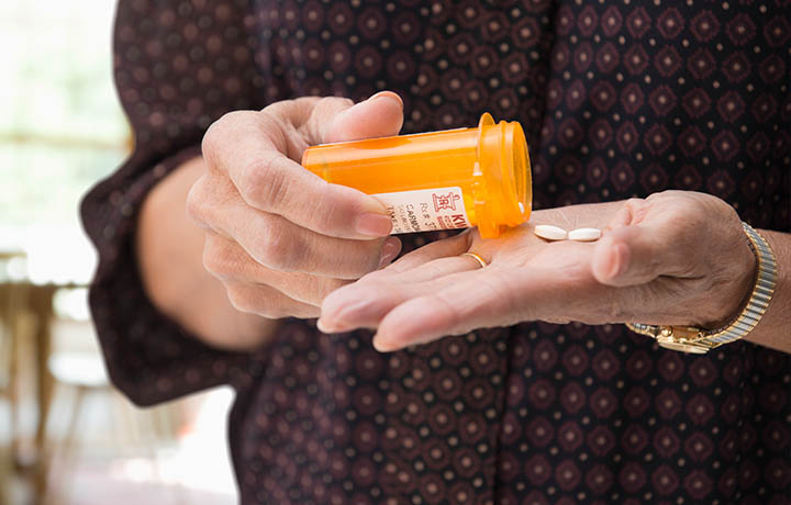 photo of a benzodiazepine tablet in the hand of an elderly female