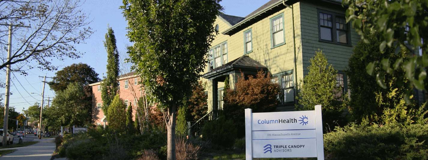 Endearing photo of a cozy neighborhood home with a healthcare facility sign out front