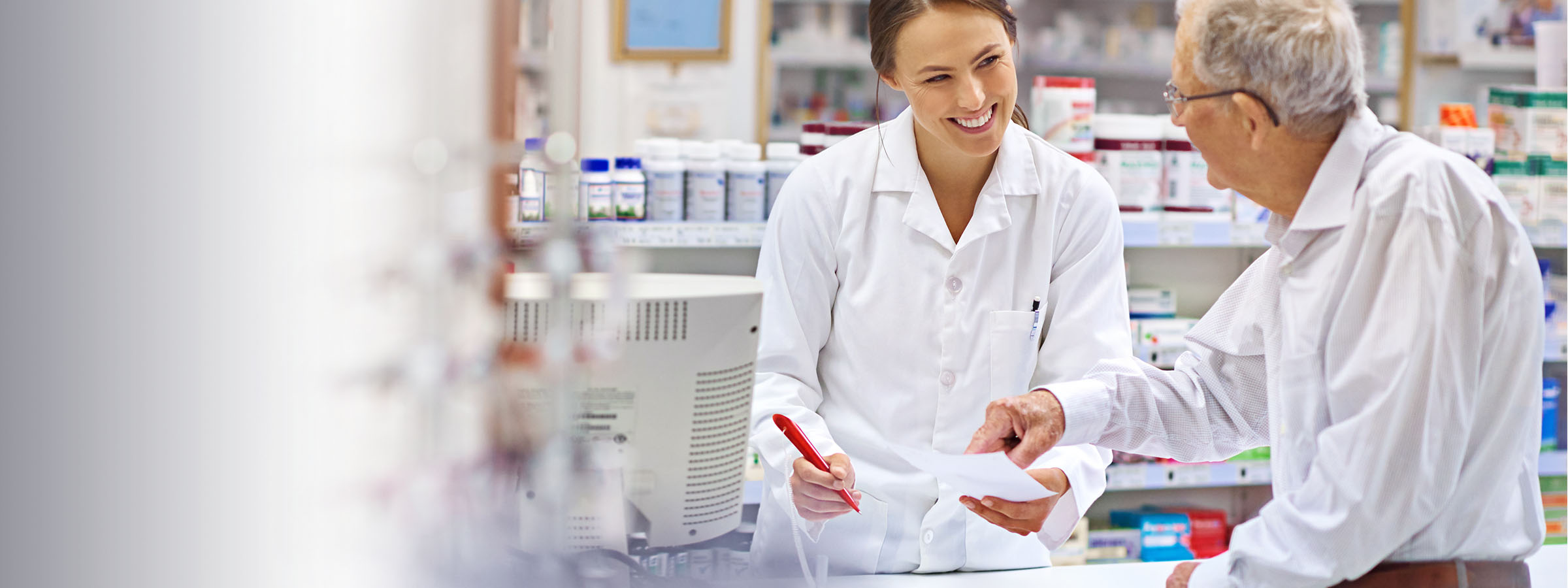 image of a female pharmacist conferring with an older male patient