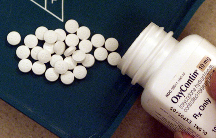photograph of an opioid prescription bottle with pills spilling out