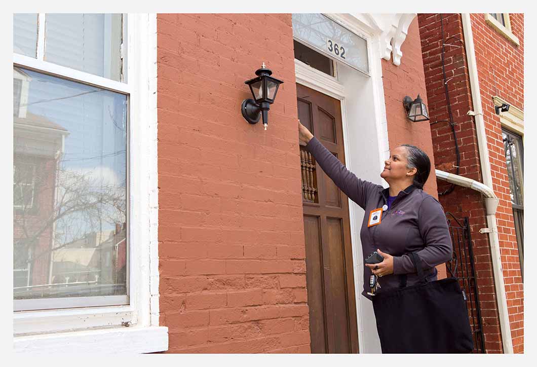 Woman standing outside a home's front door.