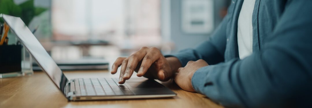 A patient uses a laptop computer to engage with his physician’s practice.