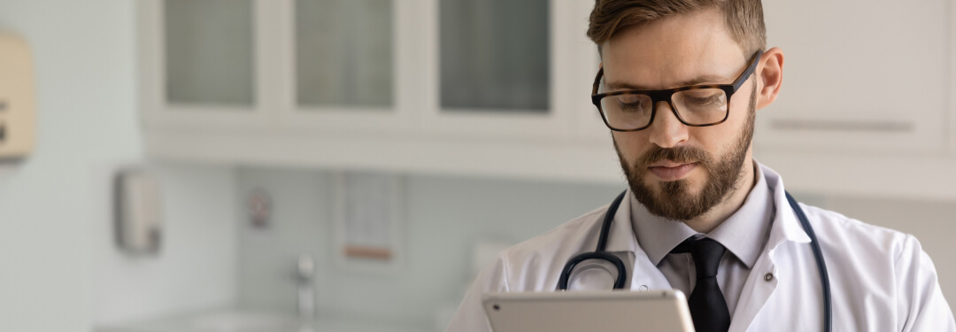 A physician interacts with a tablet, highlighting AI's impact on healthcare insights.