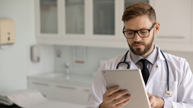 A physician interacts with a tablet, highlighting AI's impact on healthcare insights.
