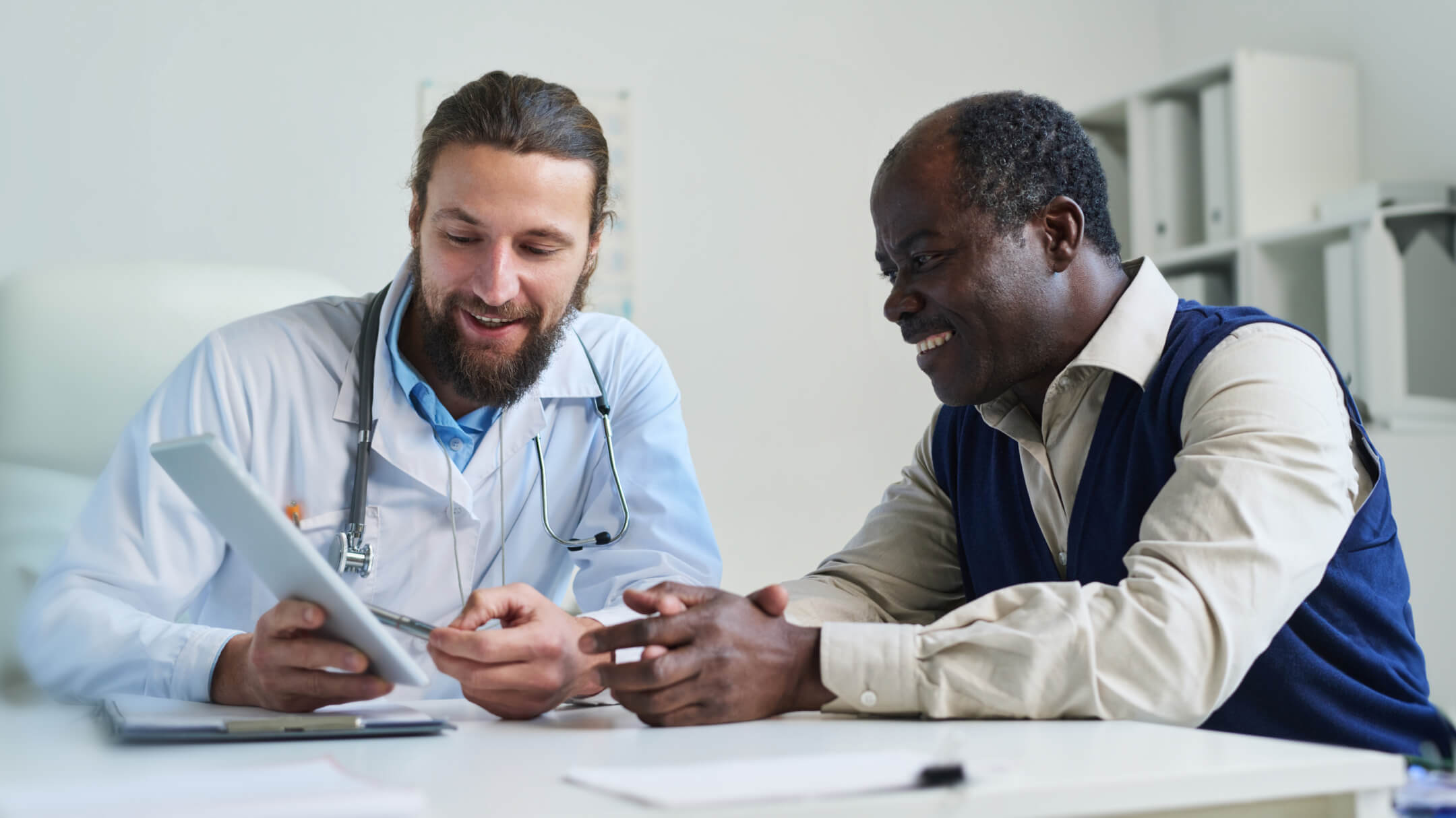 male physician reviewing electronic health record with medicare patient