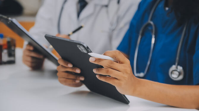Clinician checks a tablet after receiving a discharge alert through athenahealth Platform Services.