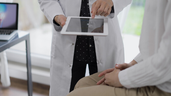Physician shows patient their chart information after using athenaOne Chart Assist.