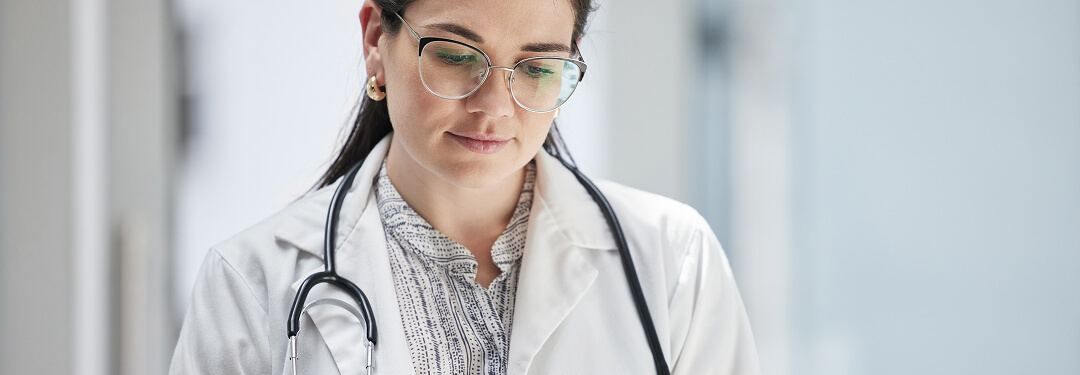 A physician interacts with a tablet, showcasing AI's assistance in managing administrative duties.