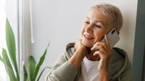A patient smiles while scheduling an appointment over the phone with athenahealth's Marketplace partner's Generative Voice AI.