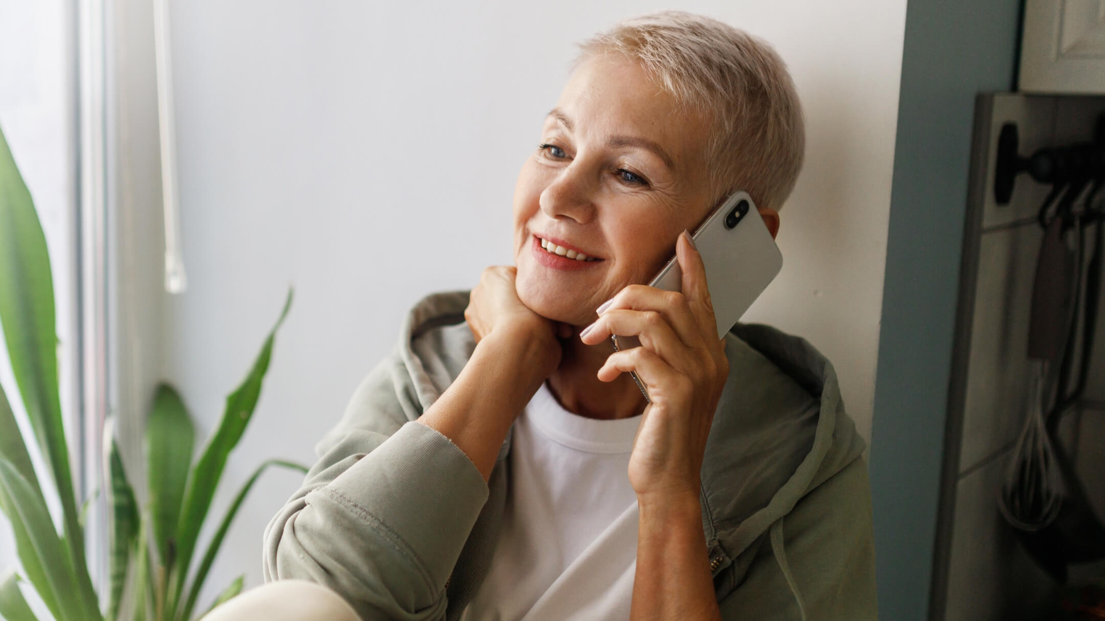 A patient smiles while scheduling an appointment over the phone with athenahealth's Marketplace partner's Generative Voice AI.