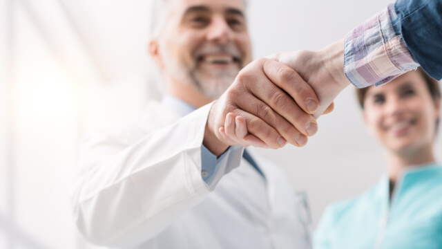 A handshake symbolizing partnership in healthcare operations.