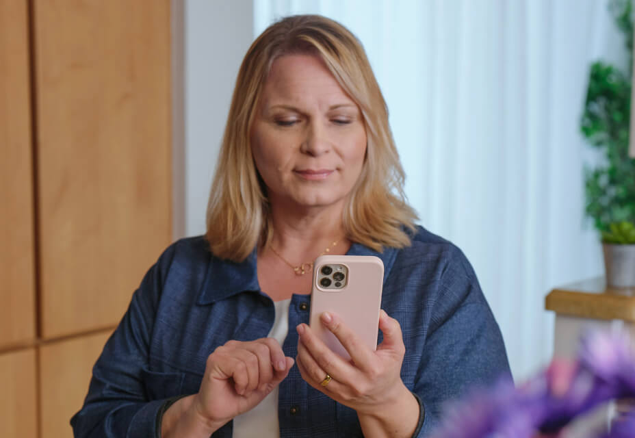 A patient appears satisfied as they answer to their healthcare team's automated wellness check via mobile phone.