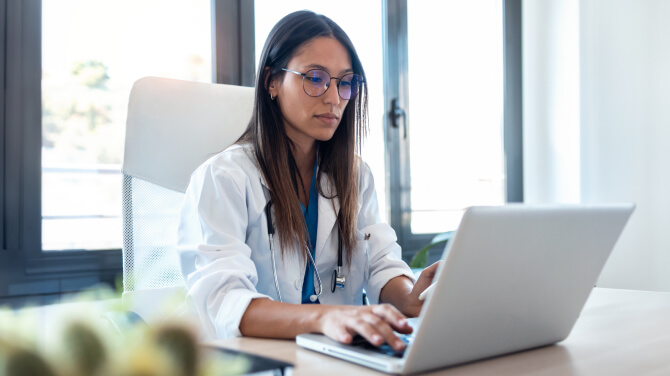A healthcare professional using a laptop to explore how AI is transforming healthcare buyer needs.