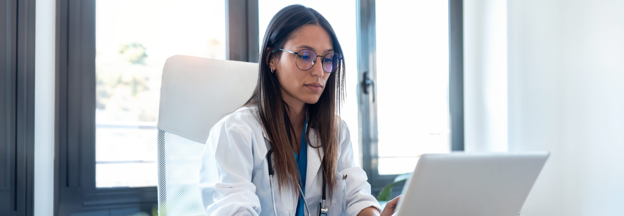A healthcare professional using a laptop to explore how AI is transforming healthcare buyer needs.