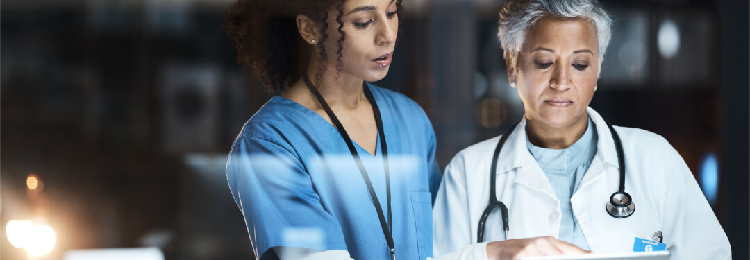 Two healthcare professionals using a tablet to access their AI-native solutions.