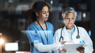 Two healthcare professionals using a tablet to access their AI-native solutions.