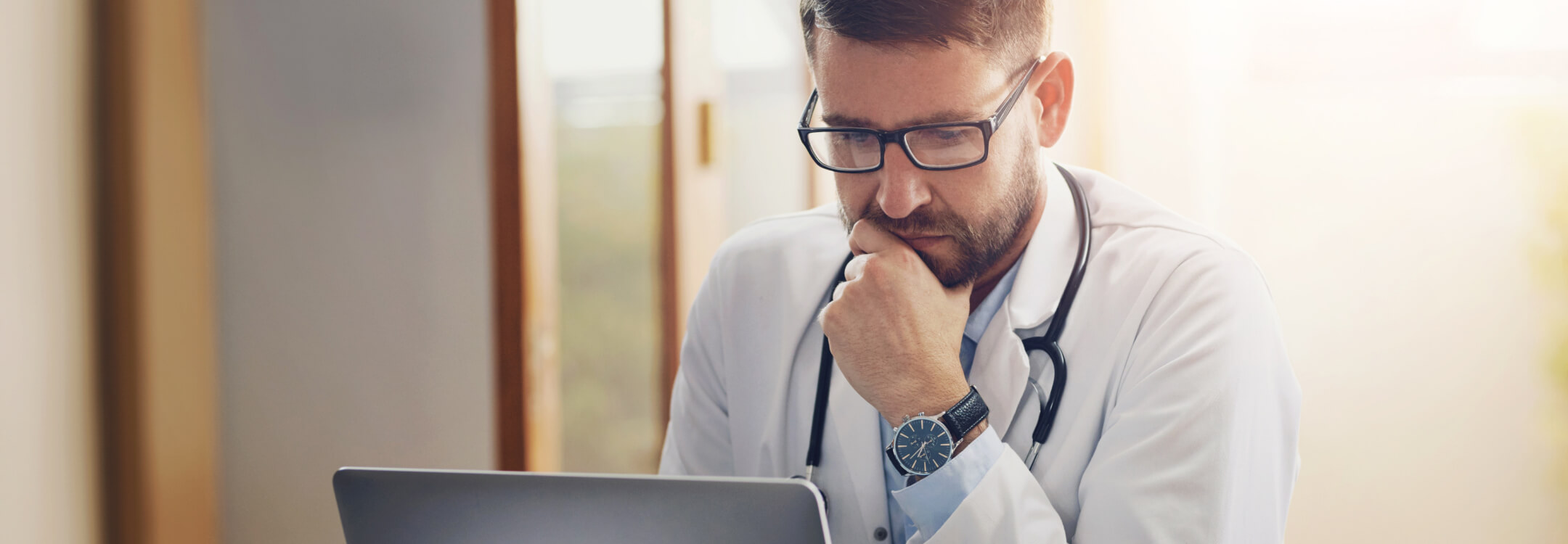 A physician at a desk with a laptop, planning the next chapter of affiliate strategy.