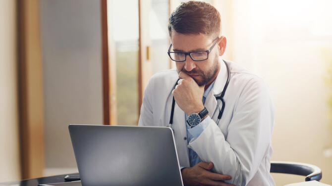 A physician at a desk with a laptop, planning the next chapter of affiliate strategy.