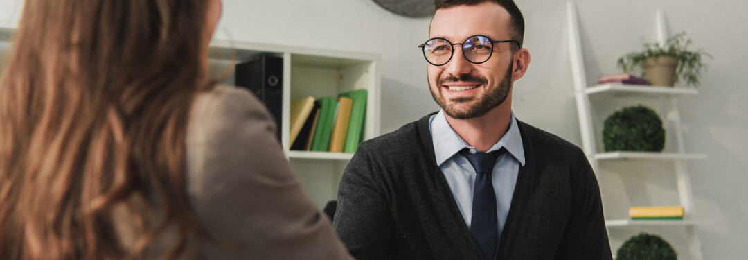 A man and woman shake hands in a modern workplace, emphasizing CSM and behavioral health partnerships.