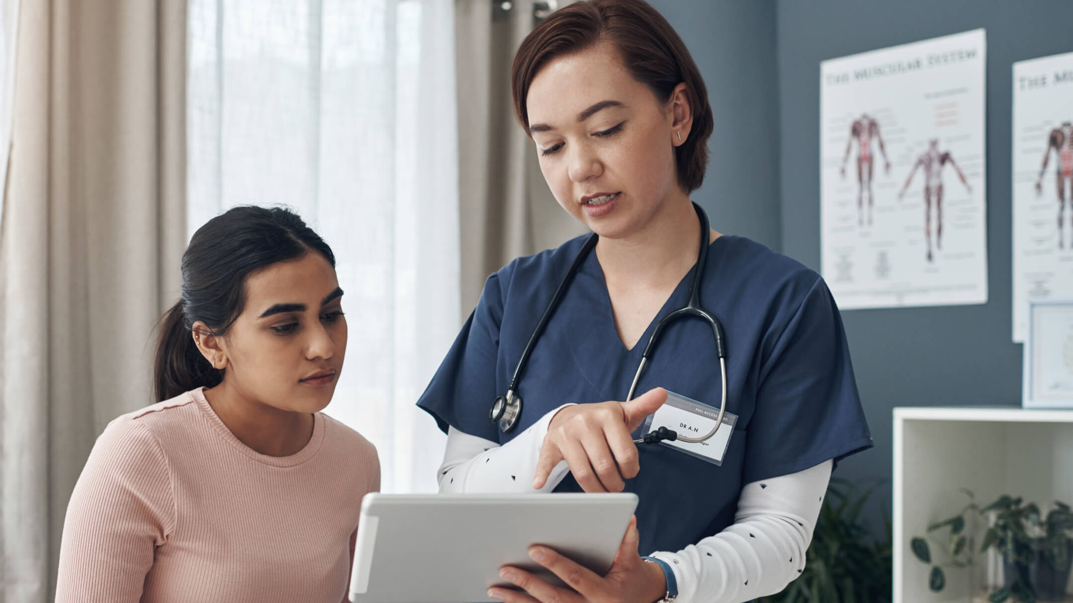 Nurse reviewing electronic health record with female patient during encounter