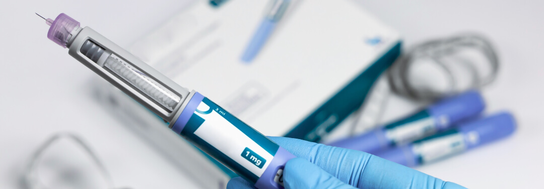 A close-up of a person’s hand holding an insulin syringe to help treat diabetes.