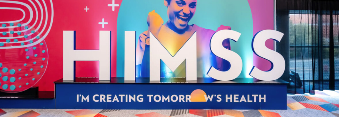 A woman shows excitement in signage for the annual HIMSS Conference