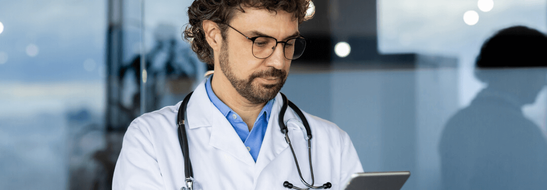 A physician is engaged with a tablet, illustrating modern charting practices.