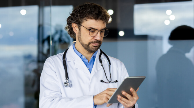A physician is engaged with a tablet, illustrating modern charting practices.