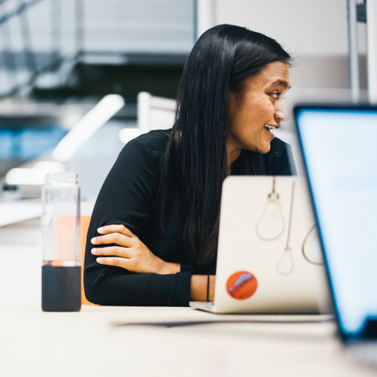 Female with laptop and water bottle in meeting