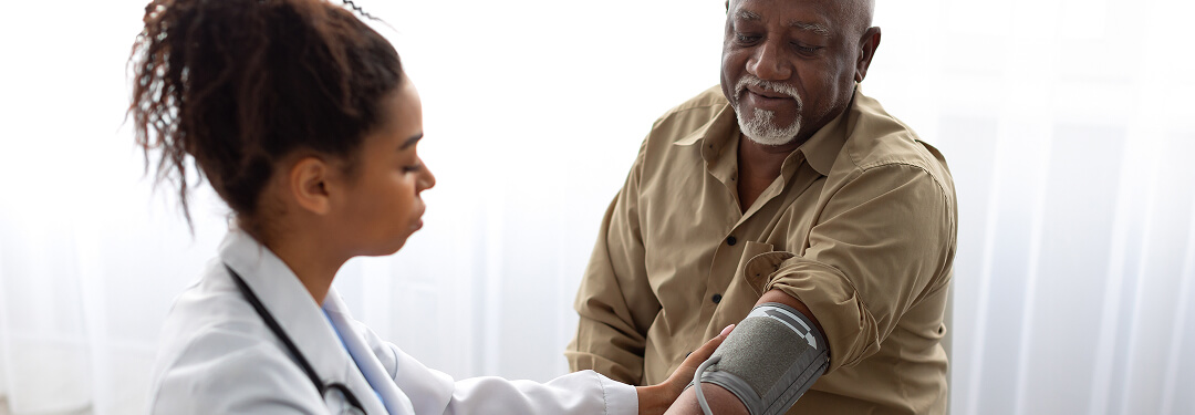 In an independent medical practice, a doctor measures a patient’s blood pressure, highlighting the importance of patient-centered care.