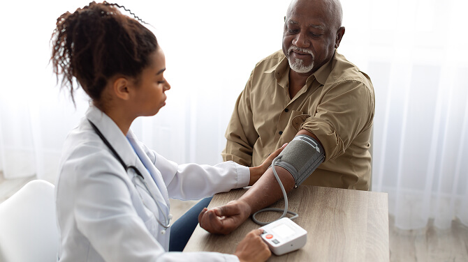 In an independent medical practice, a doctor measures a patient’s blood pressure, highlighting the importance of patient-centered care.