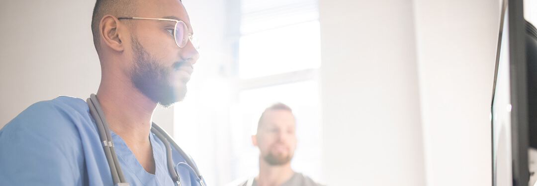 A physician utilizes a computer to demonstrate the capabilities of the athenaOne® Advanced Intelligence Layer.