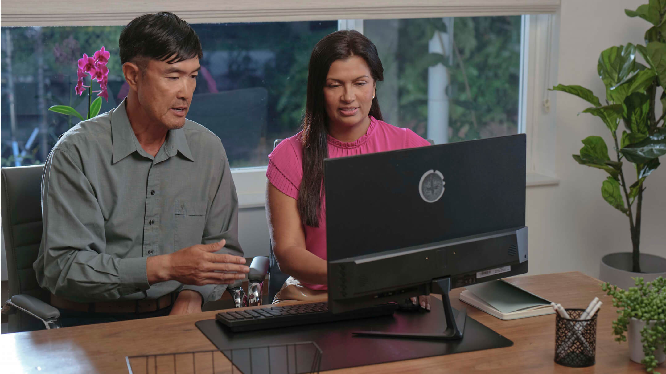Two healthcare professionals are working together at a desk, addressing challenges in healthcare practices and technology.
