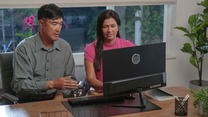 Two healthcare professionals are working together at a desk, addressing challenges in healthcare practices and technology.
