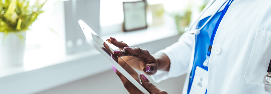A physician interacts with a tablet, utilizing medical illustration tools to improve clinical workflow efficiency.