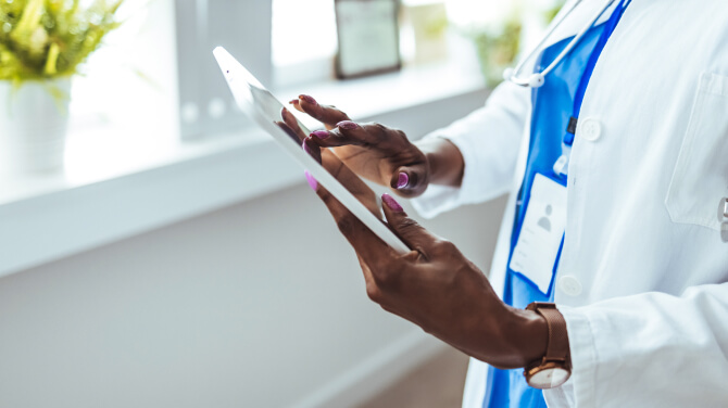 A physician interacts with a tablet, utilizing medical illustration tools to improve clinical workflow efficiency.