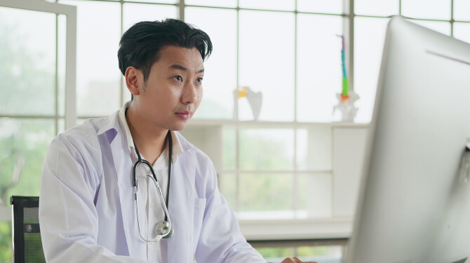 A clinician checking a patient chart after receiving an ADT alert from athenaPayer to follow up.