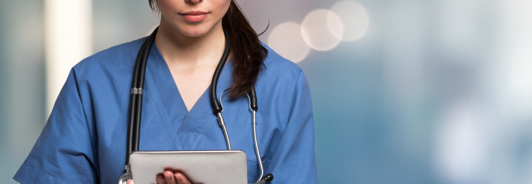 A medical professional reviews new healthcare IT software on an iPad.