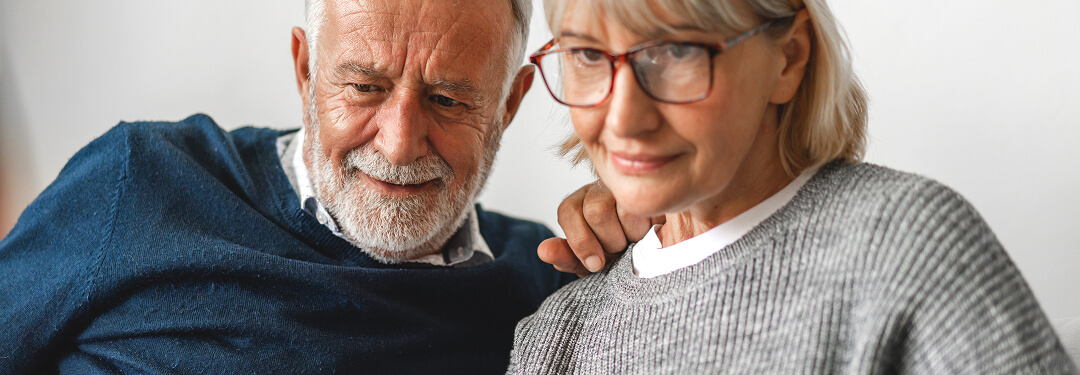 Patients are engaged with a laptop, discussing strategies for improving health plan member retention rates.
