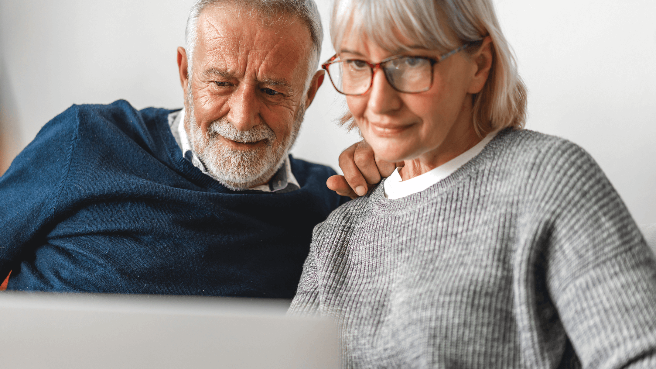 Patients are engaged with a laptop, discussing strategies for improving health plan member retention rates.