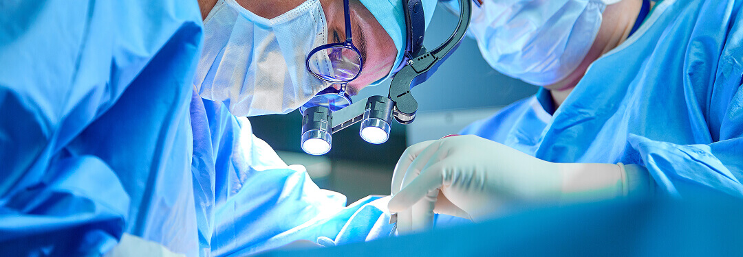 Two physicians in surgical gear inside a pain management ASC operating room.